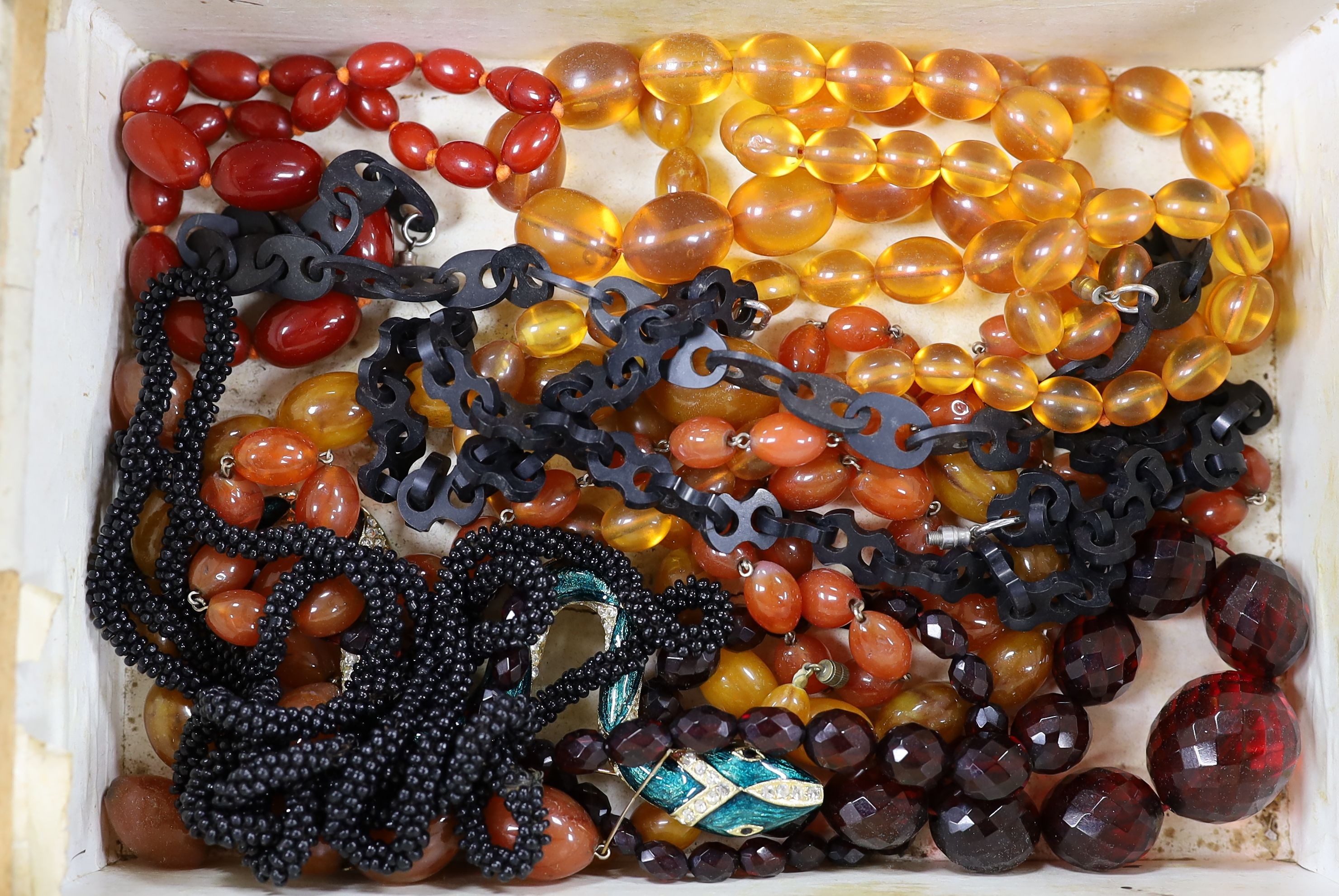 Mixed costume jewellery, including faux amber necklaces and paste set spider and serpent brooches, housed in a 19th century walnut work box.